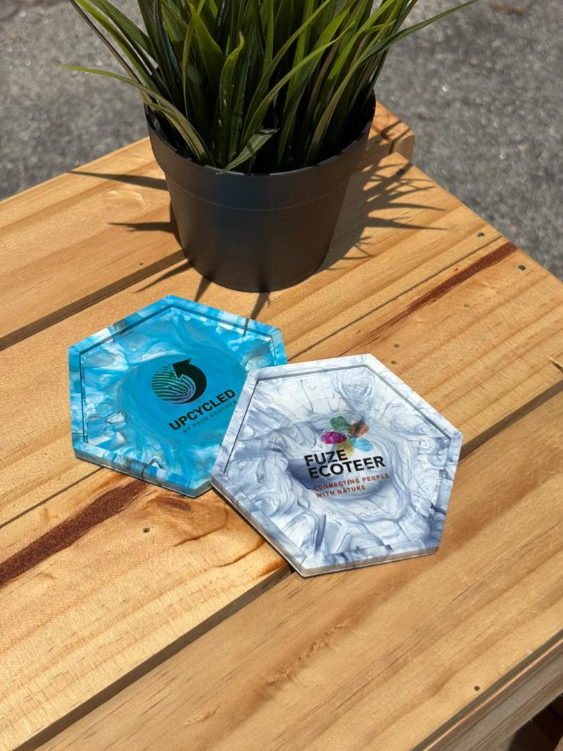 Upcycled branded coasters on a wooden surface